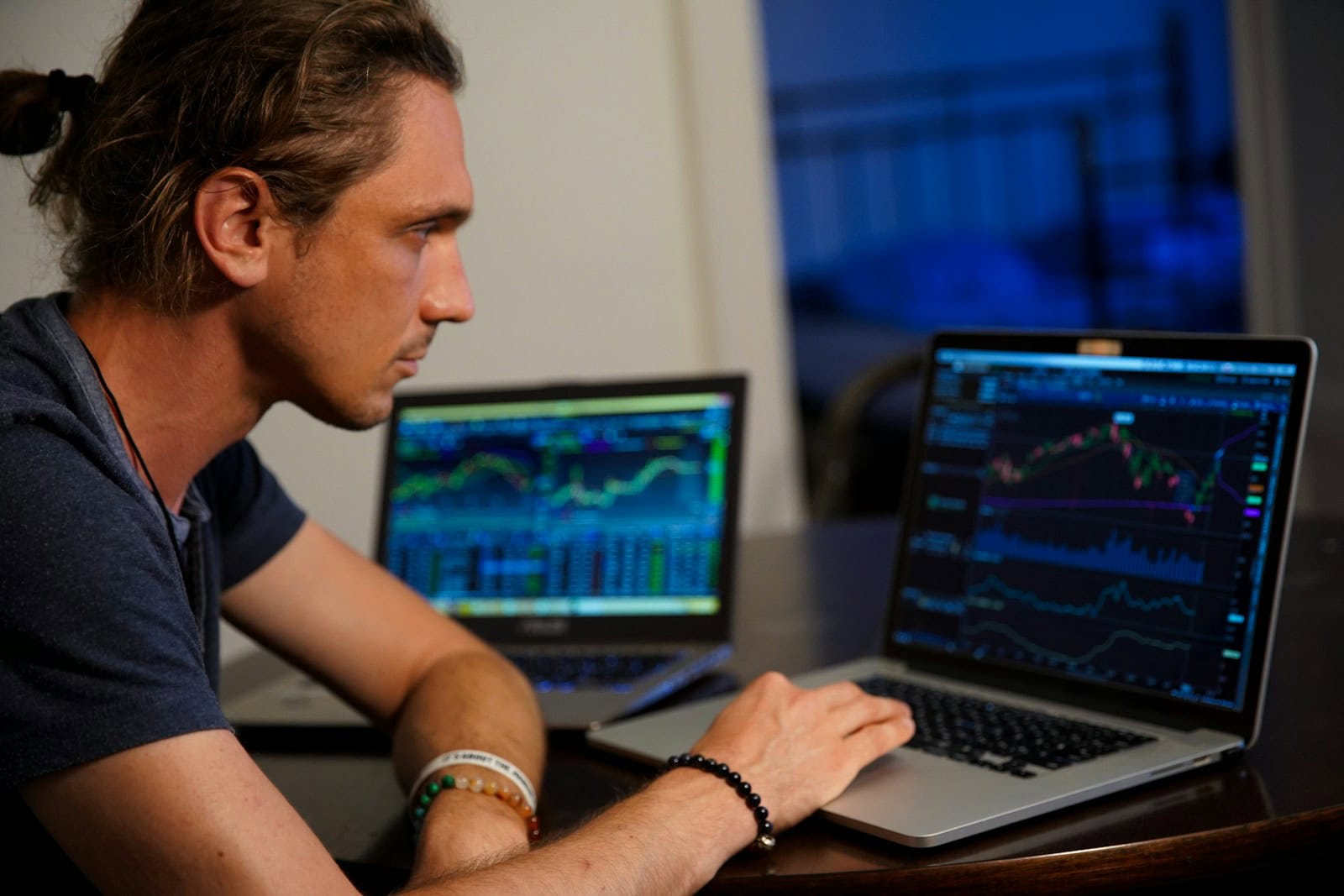 Laptop with financial trading charts showing stock market analysis and cryptocurrency graphs.